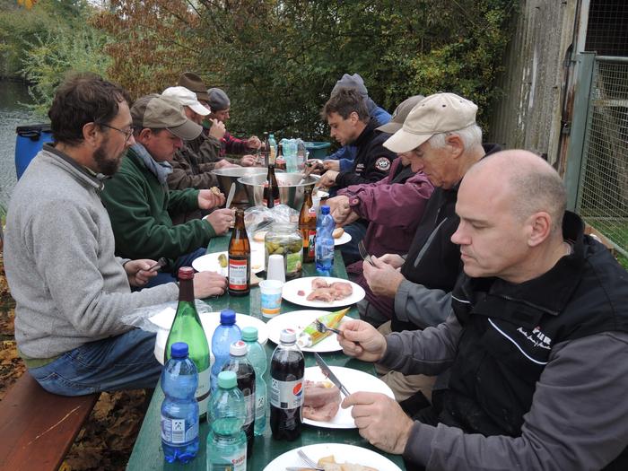 Die Fischer sitzen nach getaner Arbeit gemeinsam am Biertisch beim Essen